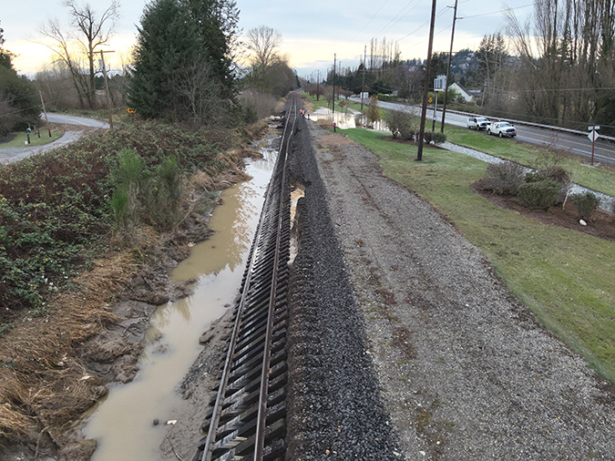 Flooding caused a washout and ballast shoulder collapse of several hundred feet of track. Flooding caused a washout and ballast shoulder collapse of several hundred feet of track.